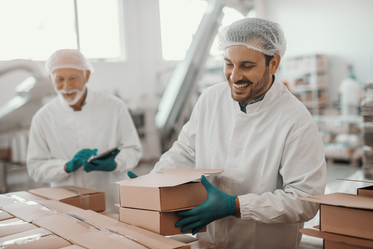 Two smiling men manufacturing food products in El Paso.